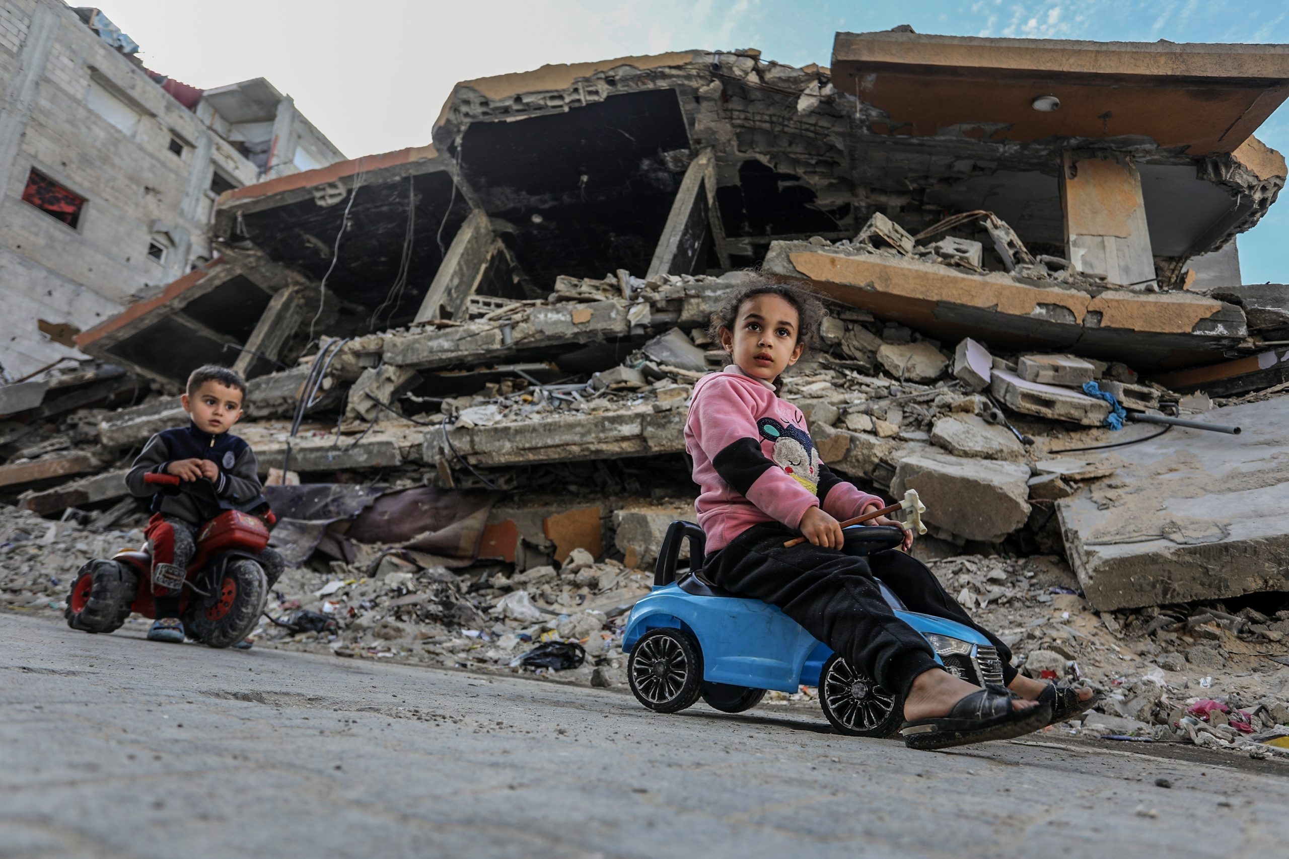 Niños palestinos juegan frente a sus hogares destruidos en Khan Younes (Gaza), el 17 de marzo de 2025. Shutterstock / Anas Mohammed