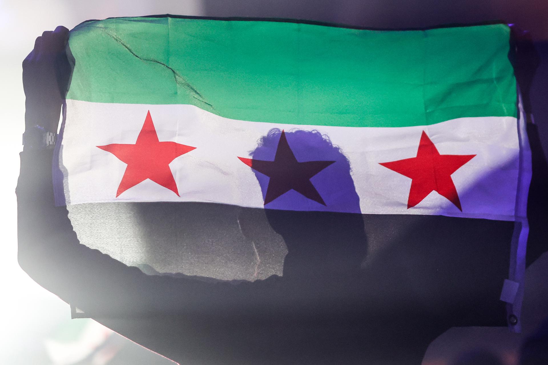 Un hombre sirio sostiene la bandera de la independencia de Siria durante la velada de celebración celebrada en París, en el interior de la Maison de la Mutualité, en París, Francia, el 1 de febrero de 2025. EFE/EPA/MOHAMMED BADRA
